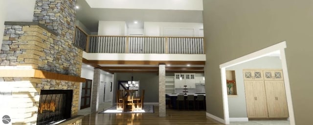 living room featuring a fireplace, a towering ceiling, and a chandelier