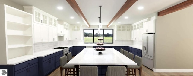 kitchen featuring white refrigerator with ice dispenser, blue cabinetry, beam ceiling, tasteful backsplash, and recessed lighting