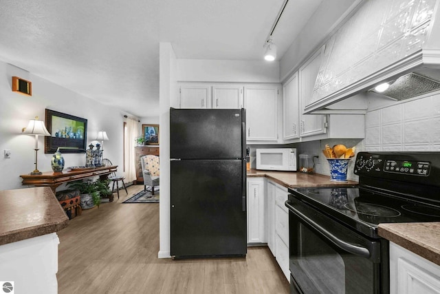 kitchen featuring custom exhaust hood, dark countertops, black appliances, light wood finished floors, and white cabinets