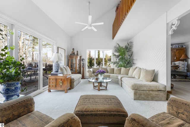 living room with high vaulted ceiling, a ceiling fan, and carpet flooring