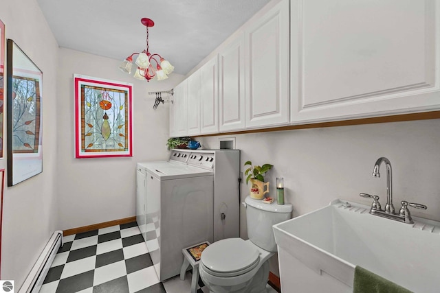 laundry room with a baseboard radiator, washing machine and clothes dryer, tile patterned floors, a sink, and a chandelier