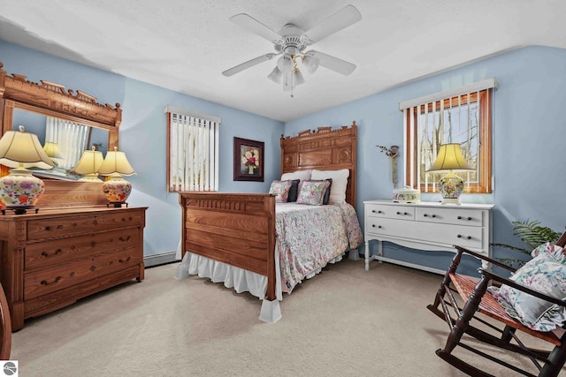 bedroom featuring baseboard heating, ceiling fan, and carpet flooring