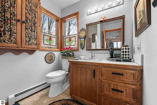 bathroom with a baseboard radiator, toilet, vanity, and plenty of natural light