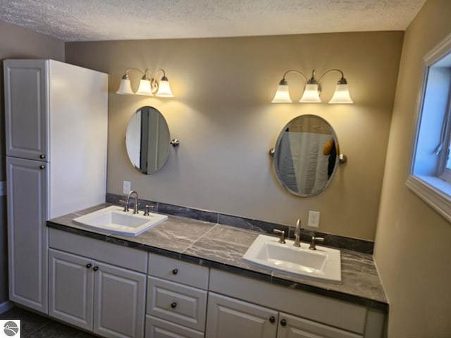 full bathroom featuring a sink, double vanity, and a textured ceiling