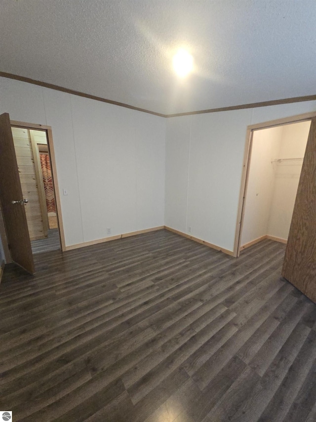 1215 S W County Line Rd, Sumner, MI 48889 - unfurnished bedroom with baseboards, a textured ceiling, ornamental molding, and dark wood finished floors