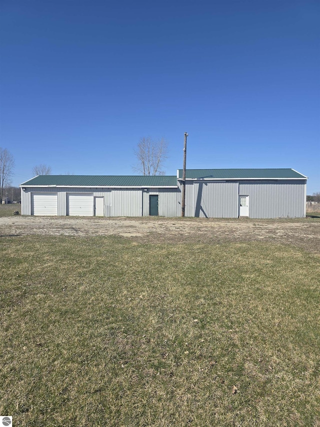 1215 S W County Line Rd, Sumner, MI 48889 - view of front of house with a pole building, a detached garage, an outbuilding, and a front lawn