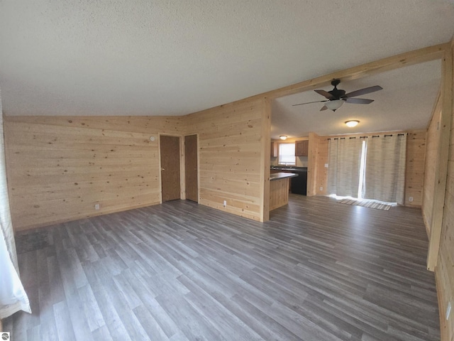 1215 S W County Line Rd, Sumner, MI 48889 - unfurnished living room with a ceiling fan, wood walls, a textured ceiling, and dark wood-type flooring