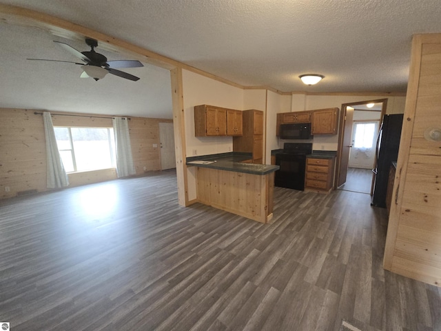 1215 S W County Line Rd, Sumner, MI 48889 - kitchen featuring a peninsula, dark wood-style floors, open floor plan, dark countertops, and black appliances