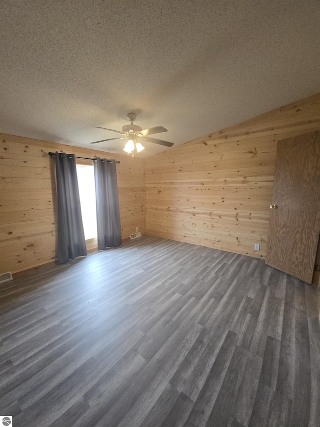 1215 S W County Line Rd, Sumner, MI 48889 - empty room with dark wood finished floors, a textured ceiling, wood walls, and ceiling fan