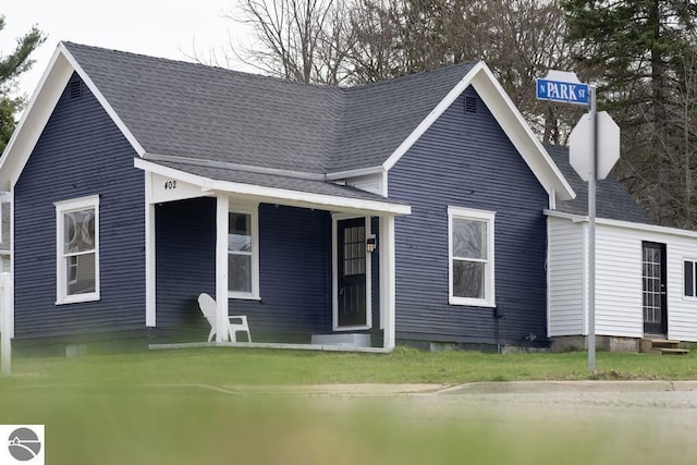 view of front facade with entry steps, a shingled roof, and covered porch