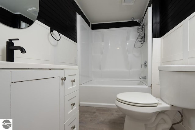 full bath featuring toilet, vanity, wood finished floors, and shower / bathing tub combination
