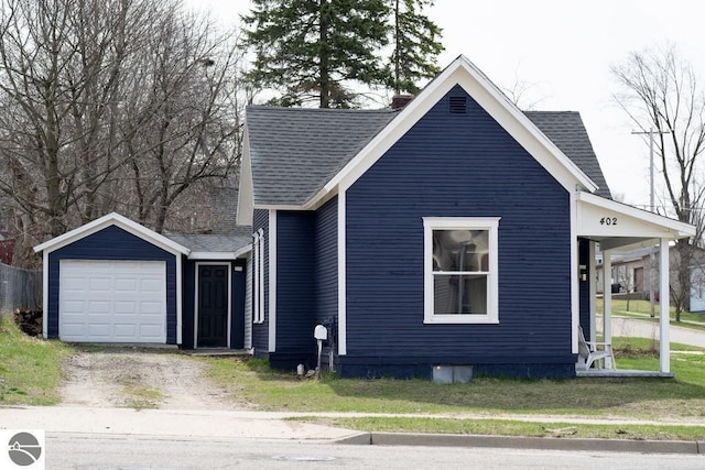 view of side of home with roof with shingles, driveway, and a garage