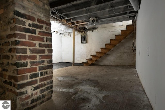 unfinished below grade area with electric panel and stairway