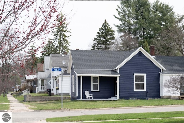 view of front of house with a chimney and a front yard