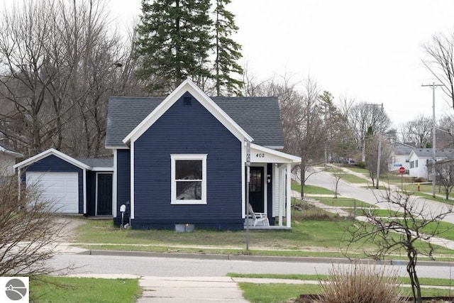 exterior space featuring a shingled roof, driveway, a front yard, and a garage