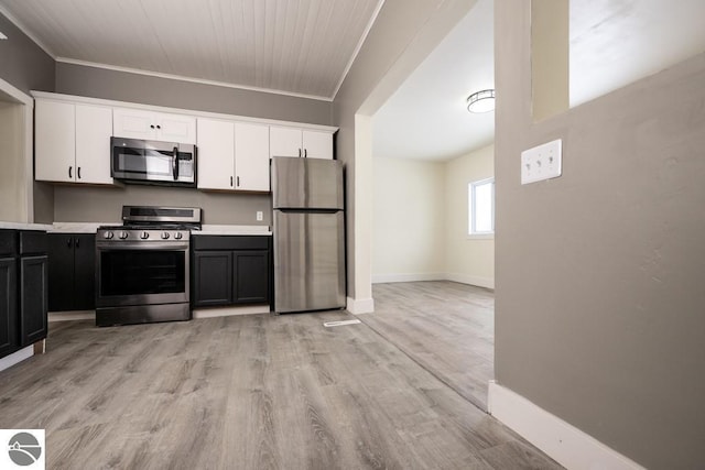kitchen featuring stainless steel appliances, light countertops, and white cabinetry
