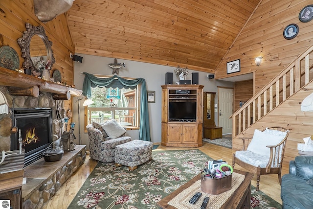 2000 Granada Ct, Weidman, MI 48893 - living area with wood walls, stairway, wooden ceiling, a fireplace, and wood finished floors