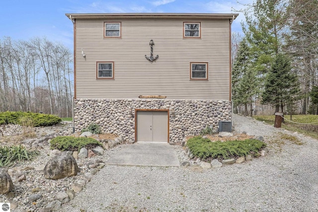 2000 Granada Ct, Weidman, MI 48893 - view of side of home featuring central AC and stone siding
