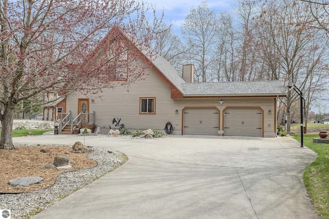 2000 Granada Ct, Weidman, MI 48893 - view of front facade with roof with shingles, a chimney, concrete driveway, and a garage