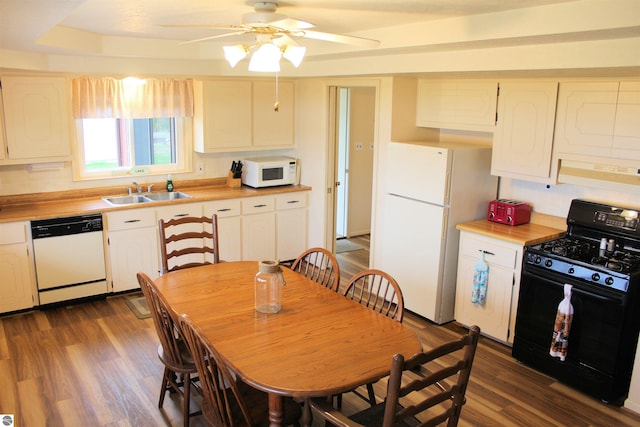 kitchen with a sink, dark wood-style flooring, ceiling fan, white appliances, and light countertops
