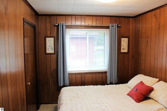 carpeted bedroom with wooden walls