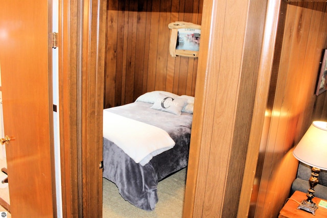 bedroom with wooden walls and carpet