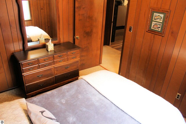 carpeted bedroom with wood walls