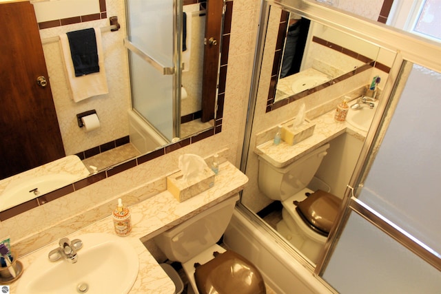 bathroom featuring enclosed tub / shower combo, toilet, and vanity