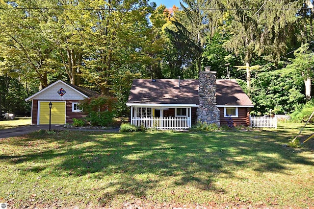 1900 Pavilion Dr, Lake City, MI 49651 - view of front of property with a chimney, a porch, fence, a detached garage, and a front lawn