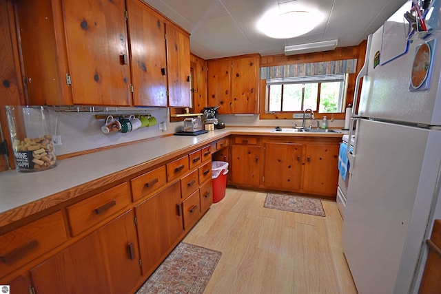 1900 Pavilion Dr, Lake City, MI 49651 - kitchen featuring a sink, freestanding refrigerator, brown cabinetry, and light countertops