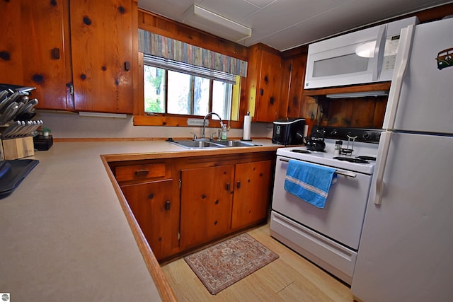 1900 Pavilion Dr, Lake City, MI 49651 - kitchen with white appliances, light countertops, brown cabinetry, and a sink