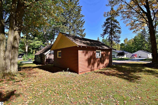 1900 Pavilion Dr, Lake City, MI 49651 - view of side of property with a garage, a yard, an outbuilding, and faux log siding