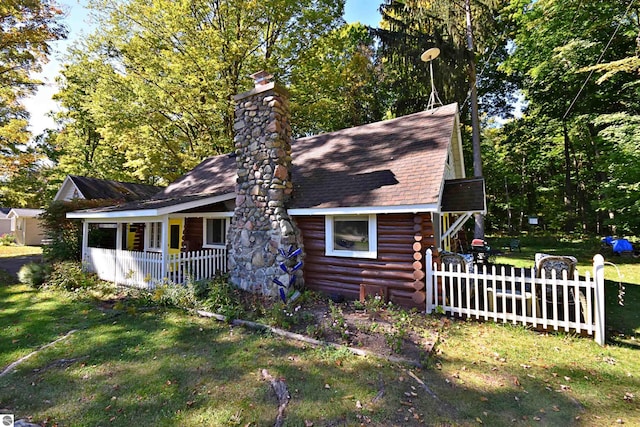 1900 Pavilion Dr, Lake City, MI 49651 - view of front of house featuring a porch, a front yard, a shingled roof, a chimney, and log exterior