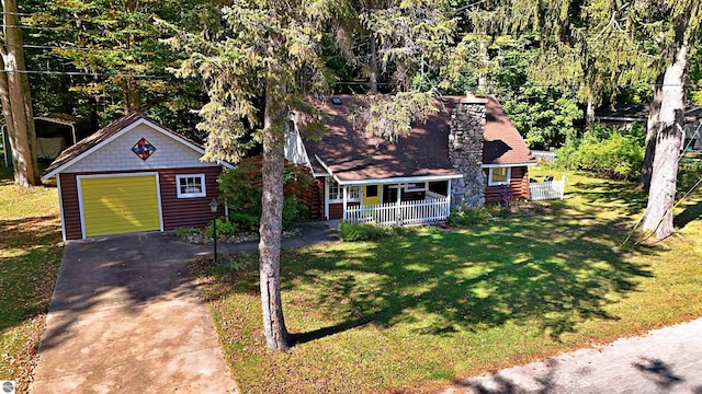 1900 Pavilion Dr, Lake City, MI 49651 - view of front of home with a porch, an outbuilding, driveway, a detached garage, and a front lawn