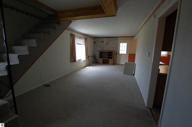 5525 S Mccauley Rd, Alger, MI 48610 - unfurnished living room featuring carpet floors, stairway, baseboards, and a brick fireplace