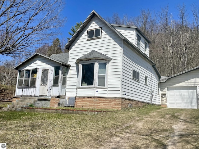 10978 Platte St, Honor, MI 49640 - bungalow featuring driveway, entry steps, a shingled roof, and an attached garage