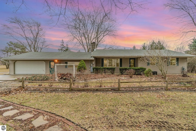 7888 E Broomfield Rd, Mount Pleasant, MI 48858 - ranch-style home with a garage, a chimney, a fenced front yard, and concrete driveway