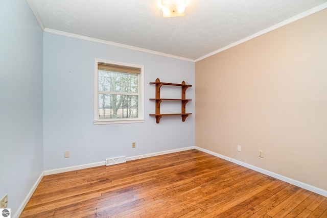 7888 E Broomfield Rd, Mount Pleasant, MI 48858 - empty room featuring wood-type flooring, crown molding, a textured ceiling, and visible vents