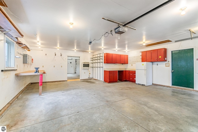 7888 E Broomfield Rd, Mount Pleasant, MI 48858 - garage with a garage door opener, heating unit, freestanding refrigerator, and baseboards