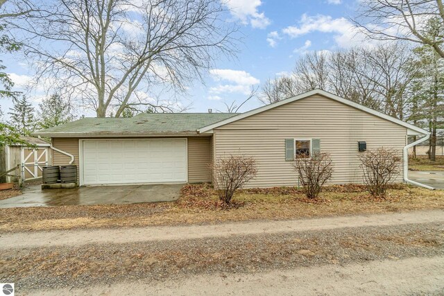 7888 E Broomfield Rd, Mount Pleasant, MI 48858 - view of property exterior featuring a garage, a storage unit, and dirt driveway