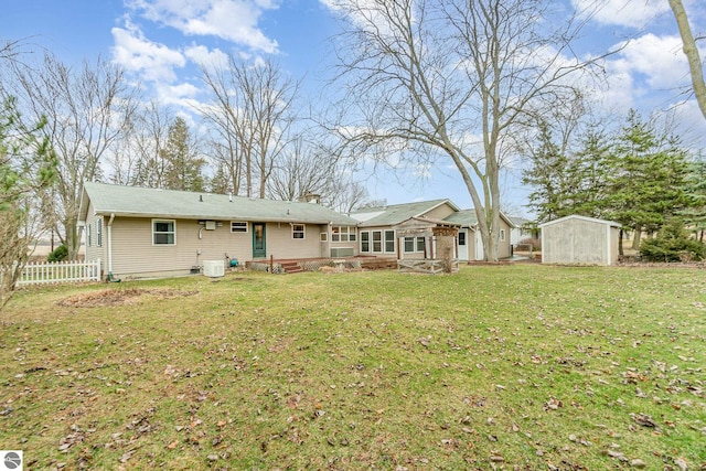 7888 E Broomfield Rd, Mount Pleasant, MI 48858 - rear view of property with entry steps, an outbuilding, a storage shed, fence, and a yard
