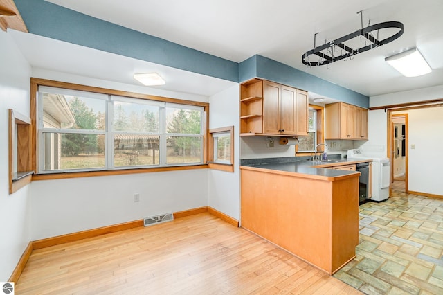 7888 E Broomfield Rd, Mount Pleasant, MI 48858 - kitchen with open shelves, washer / dryer, visible vents, a peninsula, and baseboards