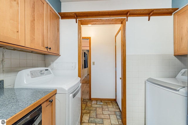 7888 E Broomfield Rd, Mount Pleasant, MI 48858 - laundry area with tile walls, cabinet space, and independent washer and dryer