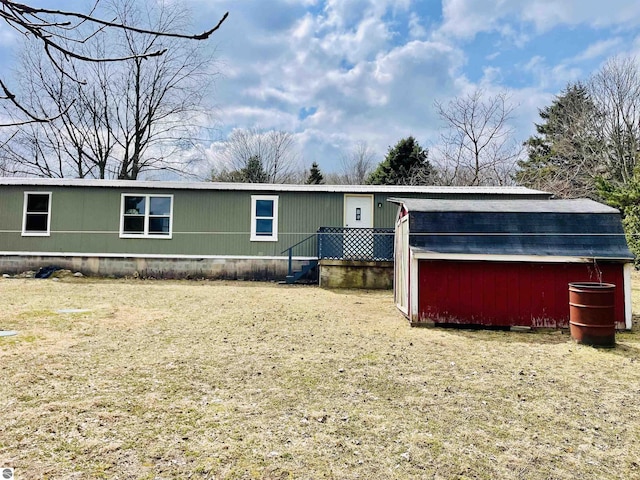 manufactured / mobile home featuring a storage shed, a front yard, and an outbuilding