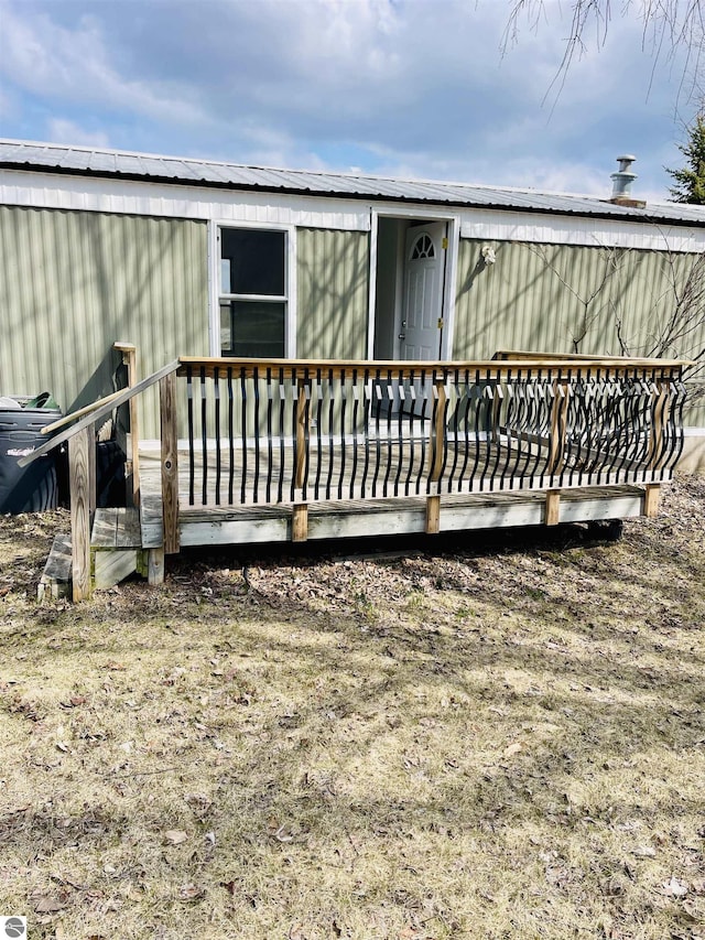 back of house with metal roof and a deck