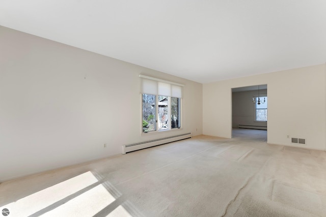 spare room featuring visible vents, a healthy amount of sunlight, and a baseboard radiator