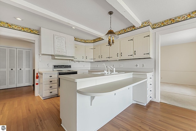 kitchen featuring white range with electric stovetop, light countertops, beamed ceiling, and a sink