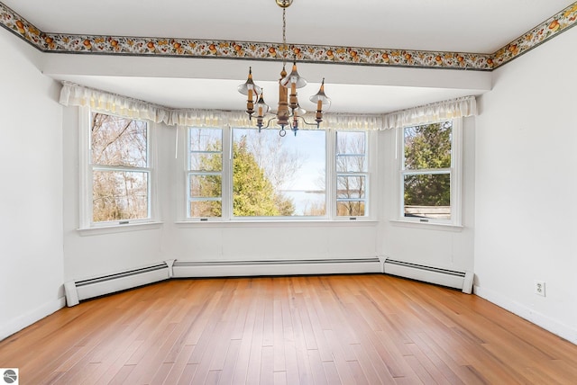 unfurnished dining area with hardwood / wood-style floors, a chandelier, and baseboards