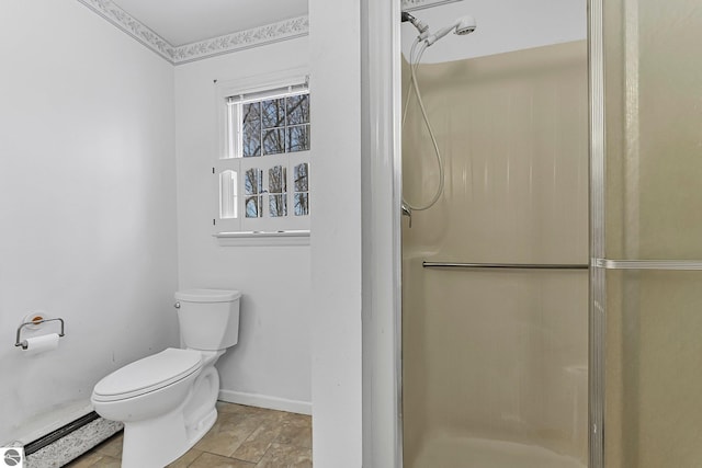 bathroom with toilet, a stall shower, and baseboards