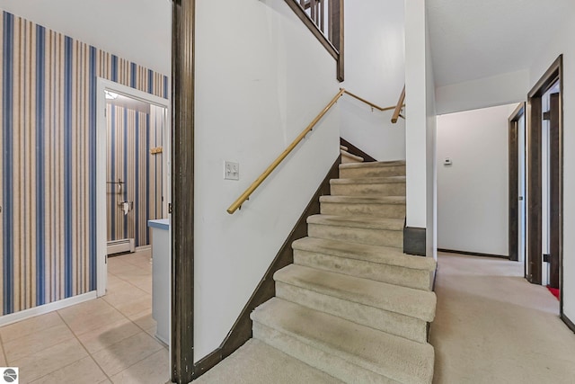 staircase featuring tile patterned floors, wallpapered walls, baseboard heating, and baseboards